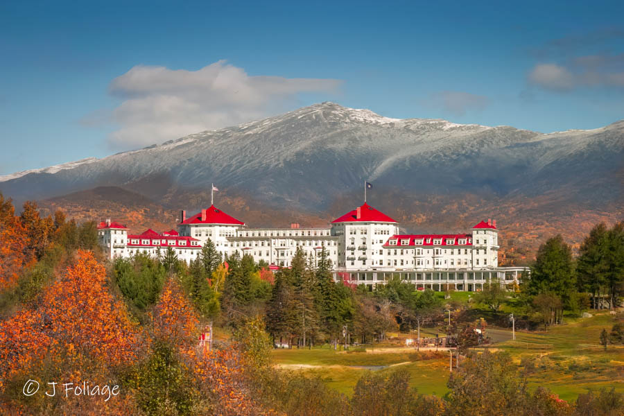 Omni Mount Washington Resort with autumn colors below and snow on top of the mountain