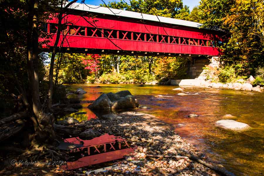 The Swiftriver covered bridge in Conway New Hampshire reflecting the red covered bridge in the river