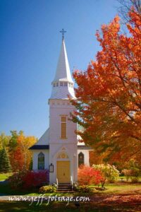 incredible hues of rainbow colors of New England fall colors over a small white church in Sugar Hill New Hampshire.#Vistaphotography #JeffFolger, #JeffFoliage,