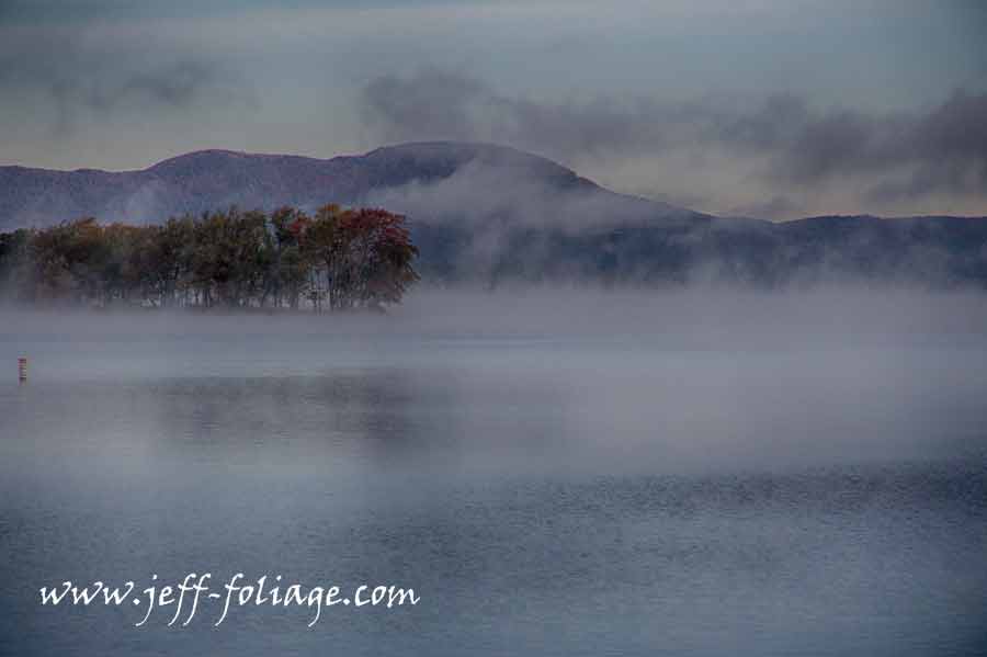 Lake Memphremagog in Newport Vermont is covered in fog during late September fall foliage season.