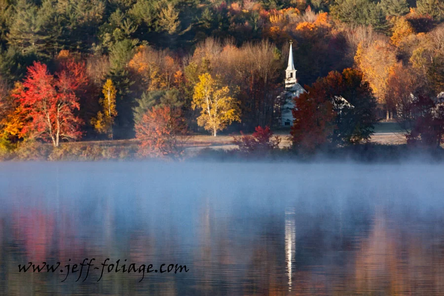 Eaton church in white with fall colors on Crystal Lake in Eaton New Hampshire