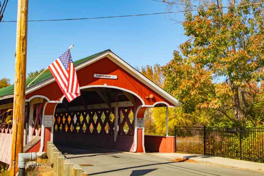 Historic red Thompson Covered Bridge in West Swanzey featuring a distinct pedestrian walkway and red portals.